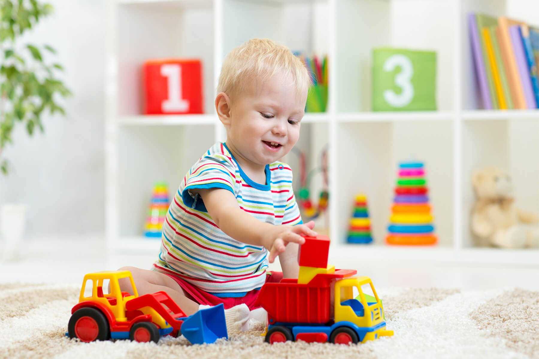 Child playing with blocks and toy trucks Child playing with blocks and toy trucks