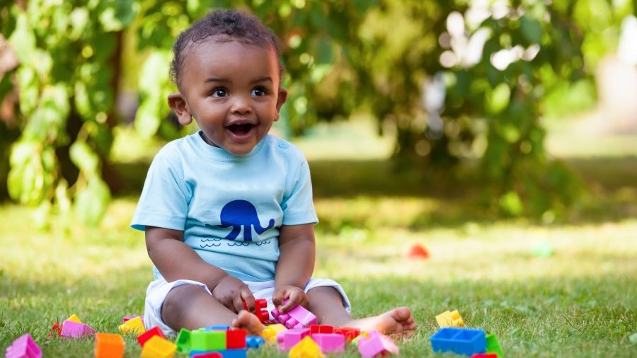 Baby playing with blocks in the grass