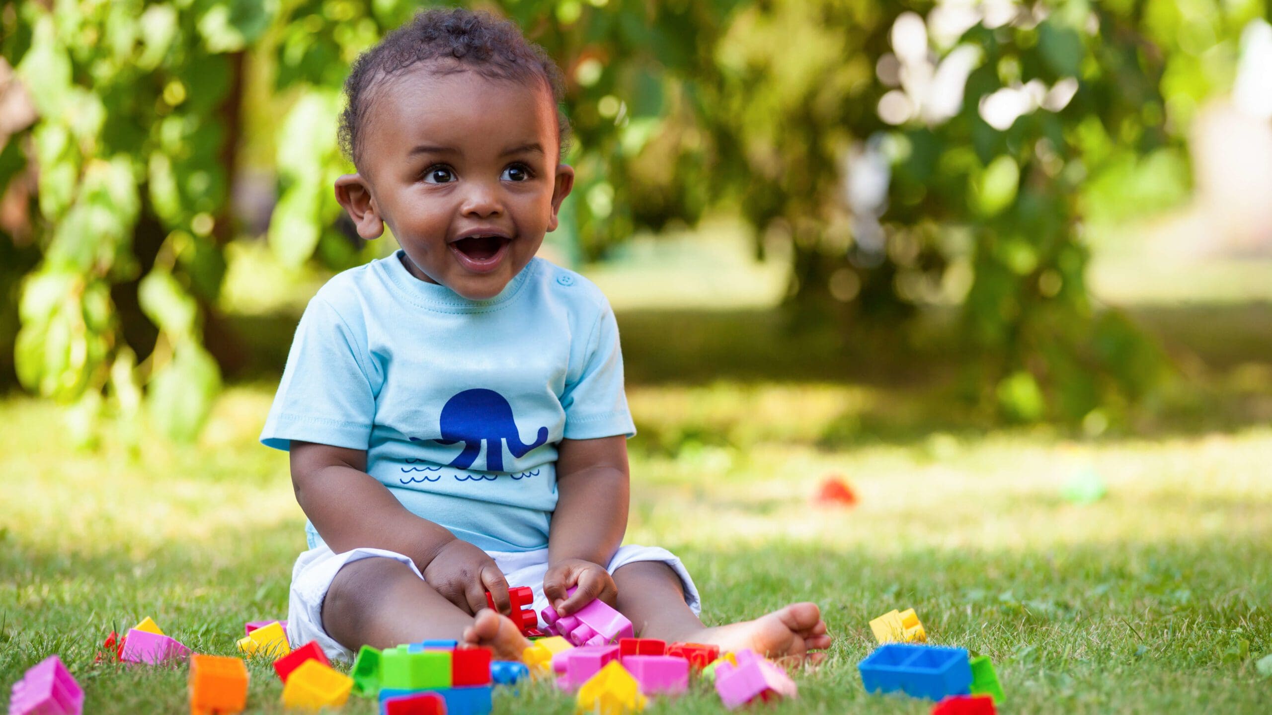 Baby playing with blocks in the grass Baby playing with blocks in the grass