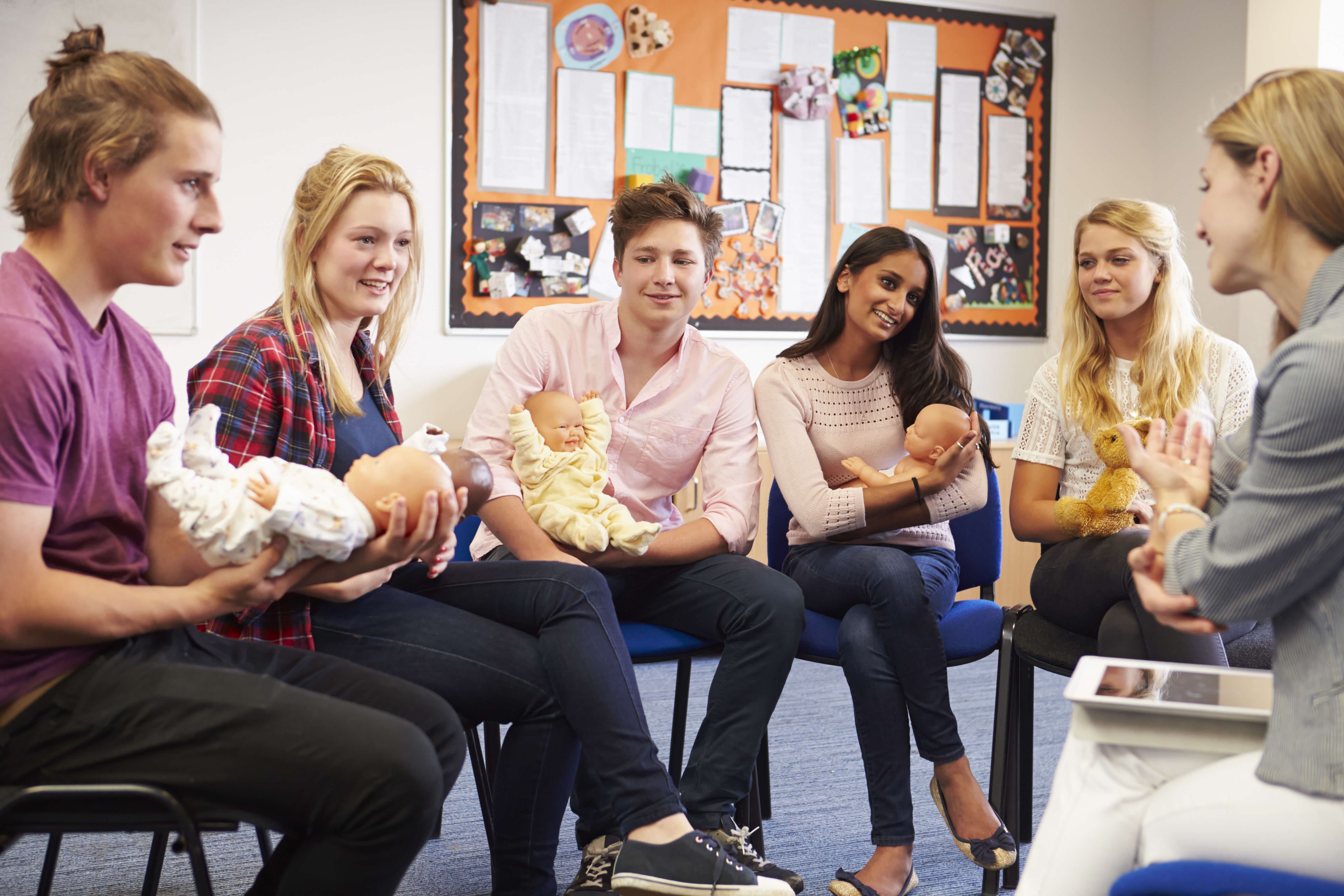 Women sitting in a circle holding baby dolls