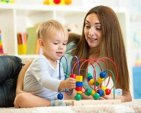 woman and child playing with bead toy