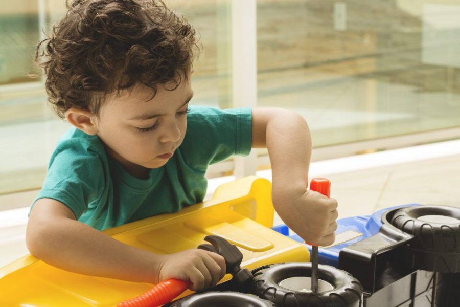 Costo de Cuidado de Niños Niño jugando con herramientas y camión
