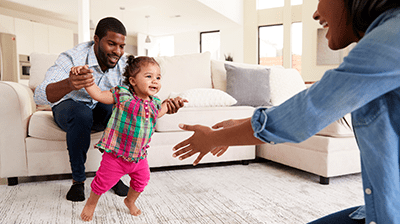 toddler learning to walk with parents