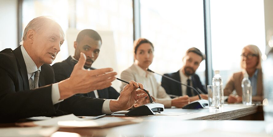 Adults in conference room speaking