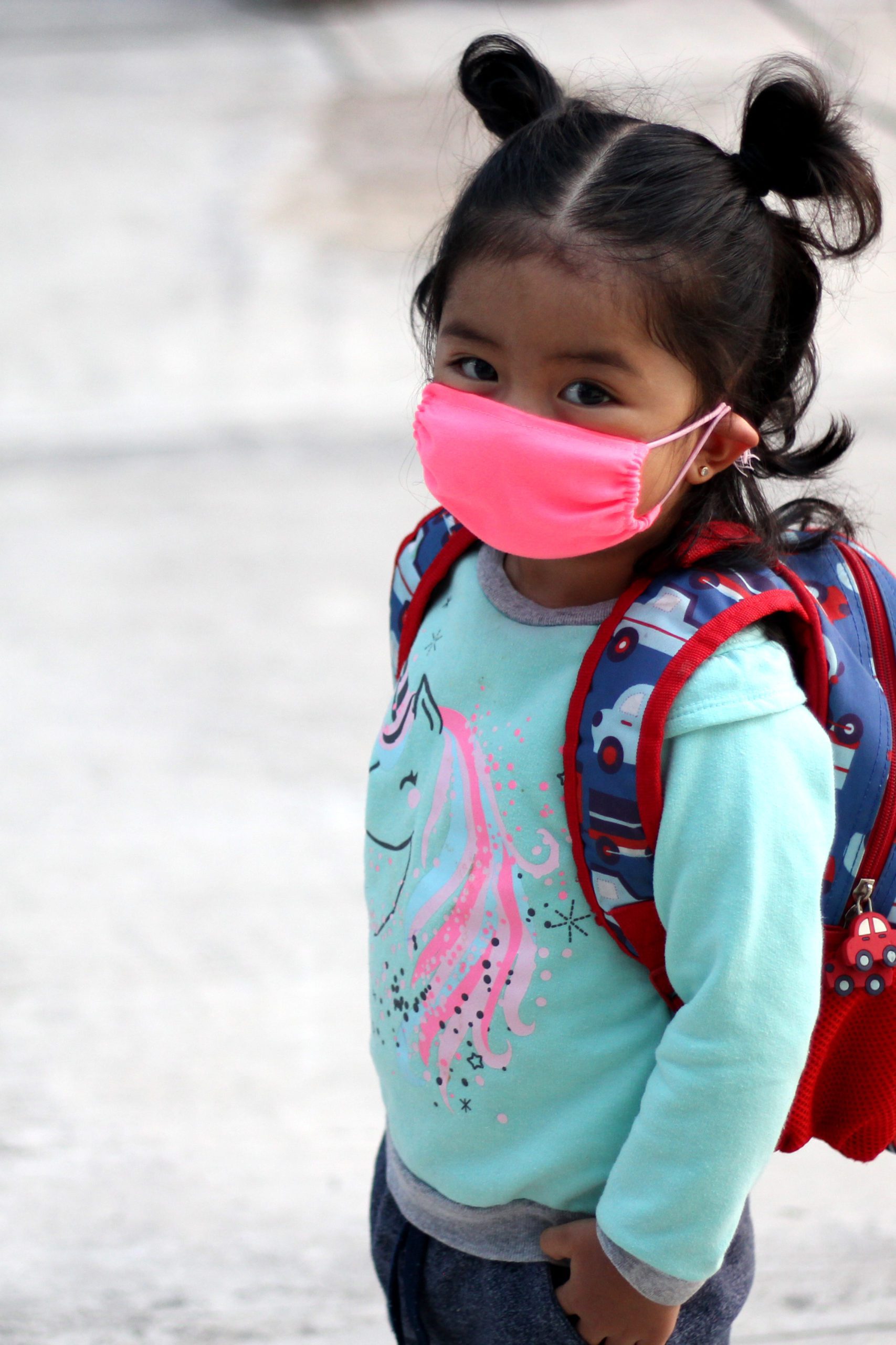 Young girl with mask and backpack