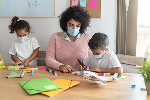 teacher-helping-children-inside-preschool-during-c-4S5LHJ4